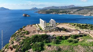 Aerial drone video of iconic archaeological site of Cape Sounio and famous Temple of Poseidon built uphill overlooking Aegean sea, Attica, Greece