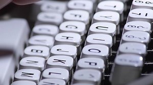 Typing in a old qwerty typewriter with white keys