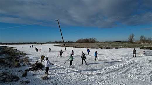 Children play ice hockey on snow-covered fields in Cambridgeshire