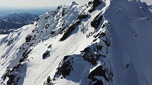 Extreme skier descending snowy mountain slope