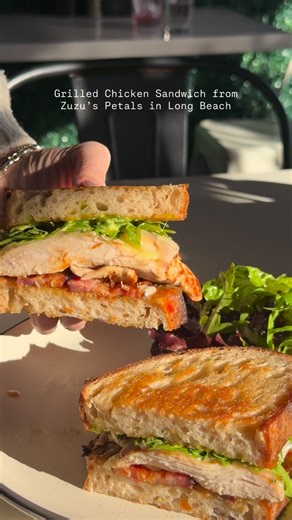 Zuzu’s Petals Long Beach on Instagram: "PICK THIS UP! Say hello to our beloved Grilled Chicken Sandwich...⁠ ⁠ local sourdough, aged fontina, house jalapeño jam, house basil aioli, @nueskes bacon, arugula, baby green salad"