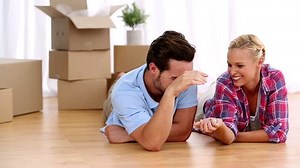 Couple lying on the floor of their new home