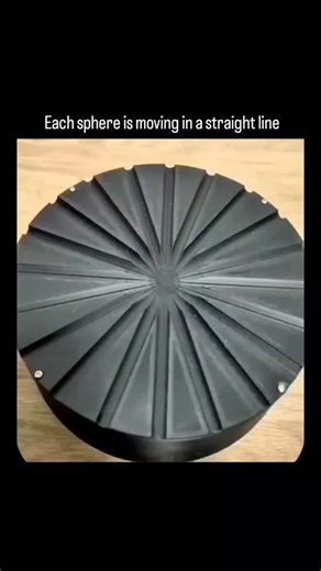 Making Cartoons on Instagram: "The post features a video of small metal spheres released onto a rotating black disk with radial grooves, creating an optical illusion where the spheres appear to spiral outward in unison, though each actually travels in a straight line due to inertia in the lab frame. - This demonstrates a classic physics principle: in a non-inertial rotating reference frame, straight-line motion appears curved, as explained in studies on fictitious forces like the Coriolis effect