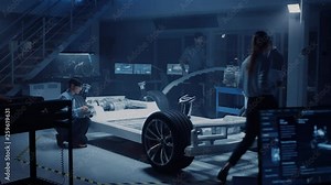 Automotive Design Engineers Work and Do Tests on Electric Car Chassis Prototype. In Innovation Laboratory Facility Concept Vehicle Frame Includes Wheels, Suspension, Engine and Battery.