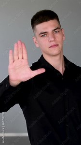 Stop hand sign. Handsome man with black hair and blue eyes. Mixed race nationalityPortrait of Man Showing Stop Sign by Hand