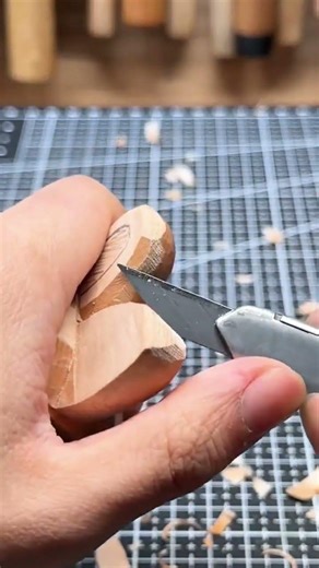 carving wood with a utility knife to create thin shavings and reveal the grain of the wooden piece