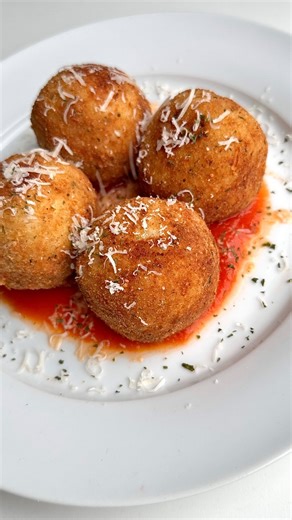 HOLIDAY DINNER SERIES: Ep.27 Rice Balls ✨ 2 cups of Arborio rice 3 tbsp of olive oil 1/2 cup of white wine 4-5 cups of chicken broth (warmed) Salt 3 eggs 1/2 cup of parmigiano cheese 1 cup of mozzarella cheese (small cubes) 1 cup of breadcrumbs (unseasoned) 1 cup of flour 1 tsp of parsley Salt and pepper for seasoning In a medium pan on medium high heat; heat olive oil and toast the Arborio rice for a few minutes. Pour in the white wine, stir, and allow to reduce. Lower heat to medium- low and s