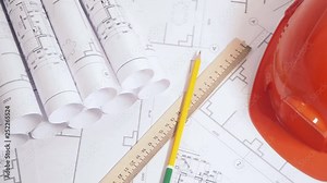 Paper architectural drawings, blueprint and helmet. Engineering blueprint