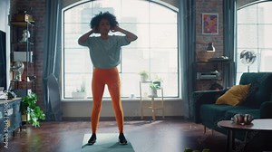 Concentrated Positive Black Woman Doing Cardio High Knees and Squat Exercises During Daily Workout at Home. Strong and Fit Girl Leading Healthy Lifestyle. Fitness and Recreation Concept