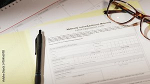 Maternity leave application blank document form with glasses and a pen