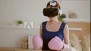 Virtual Metaverse Augmented Reality asian female adult working out boxing in VR headset aerobic training for boxing punch in virtual reality at living room home interior background