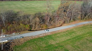side view of car driving through the country in the fall