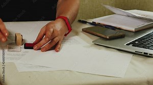 Close-up of a woman's hand that puts a stamp on a piece of paper Stock Video