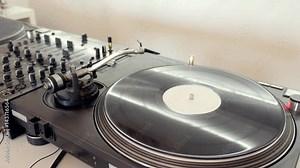 Footage of an audio mixer with a vinyl player and a rotating vinyl on it...