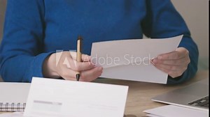female hands opening envelope letter document or bills, reading, writing down notes. opening mail, loan, bank docs, papers, tax refund or notice. money coins salary or wedges income, planning budget