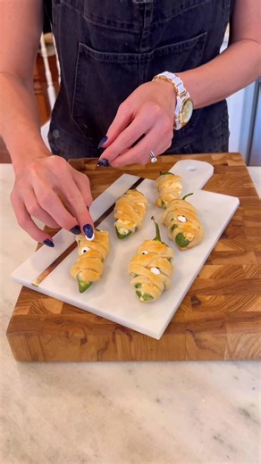 Save these for an easy Halloween appetizer. This crazy-simple recipe evocative of your restaurant favorite is made delicious with just four simple ingredients: jalapeño chiles, cream cheese, cheddar cheese and Pillsbury crescent rolls. Add candy eyes for the mummy effect. 👻 Cook on 375 for 15 minutes. #halloweenappetizer #jalapenopoppers | Mackenzie Biehl