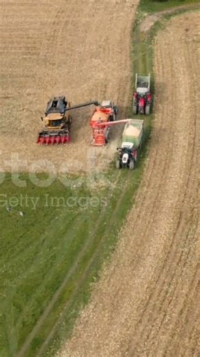 Drone aerial video with a combine harvester unloading corn into a portable mill