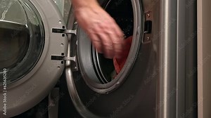 Man hand put color absorbing sheet inside a washing machine, allows to wash mixed color clothes without ruining colors concept.