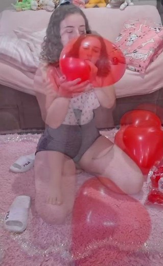 Cute Looner Girl Plays with Small Red Heart Balloons