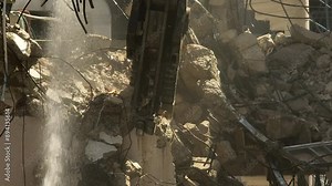 Building demolition excavator using Pulverizer Jaws to demolish a residential building