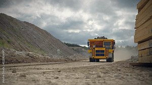 Large quarry dump truck in a coal mine. Loading coal into body work truck. Mining equipment for the transportation of minerals.