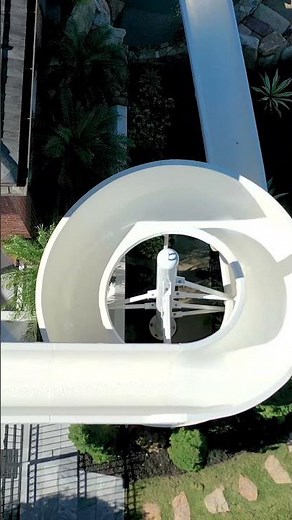 Natural Rock Infinity-edge Pool with 121-Foot Water Slide starting from the second-floor balcony.