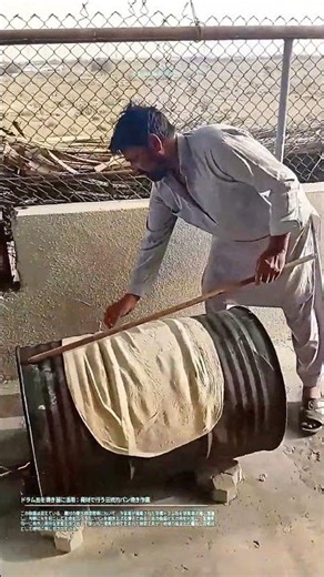 ドラム缶を焼き器に活用：廃材で行う伝統的パン焼き作業