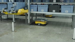 Demonstration of Smart warehouse management system with robotic handling system. Automated robotic tote arranging distribution product stock on shelf in modern factory. AI Technology Logistic concept.