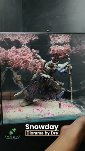 GreenDecor.Diorama on Instagram: "“Snowfall Requiem” Amid the last snow of winter, beneath blooming cherry blossoms, a lone soldier returns to visit his old partner — a battle-worn robot long fallen silent. Rusted armor, cracked plates, and drifting petals tell the story of years gone by. No engines, no steel roars… only a quiet reunion as spring begins to breathe again. #diorama #dioramamaker #miniature #customfigure #mecha #moshowtoys"