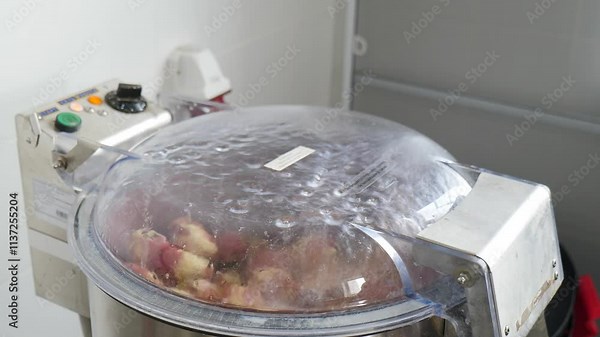 Industrial vegetable processing features a machine with a clear lid, showcasing fresh vegetables being chopped, sliced, and blended for streamlined food production. Rerstaurant or canteen concept. 4 k Stock Video