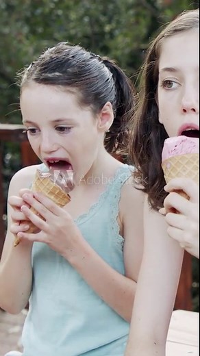 Young girl eating Ice Cream from a cone, enjoying and laughing
