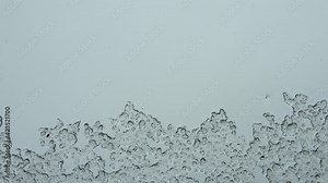 Hail running down a window during heavy weather. Melting ice time lapse