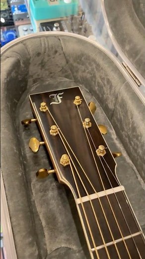 Unclasping a Furch Vintage 2 D-Sra Dreadnought Acoustic Guitar