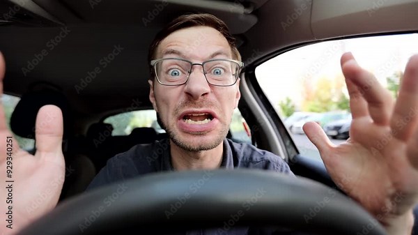 Angry man driving a car. Male driver screaming behind the wheel of the car.