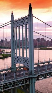 Beautiful structure of Triborough bridge with quick traffic. Amazing bridge structure at the backdrop of cityscape under the pink sky. Vertical video