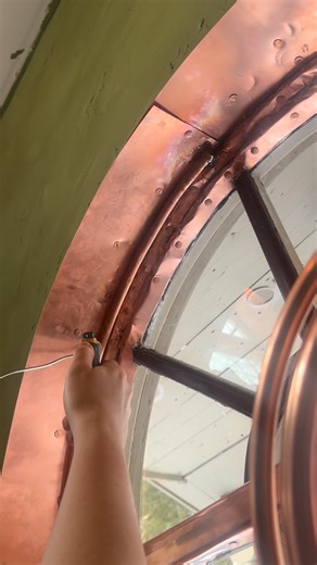 Abigail Brower Spath on Instagram: "Found these half circle windows for cheap and painstakingly made them in to a circle window. Didn’t film a thing thinking I would slip up and crack a pain. But I didn’t and Decided to not stop there and make them copper windows with scrap pipes and other stuff. #coppersculpture #diy #homedecore #copperwindow #roundwindow"