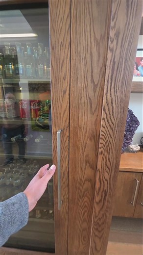 Custom-built solid wood wine fridge enclosure with rich walnut grain #CustomCabinetry #LuxuryHomes