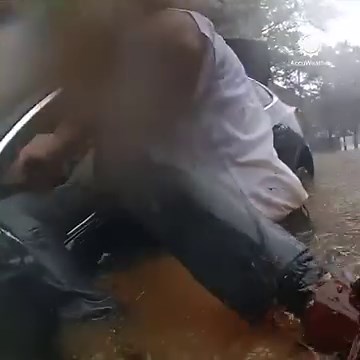 An intense moment of heroism: Atlanta Police officers spring into action, rescuing a trapped driver from their vehicle amidst heavy rains and severe flooding. | AccuWeather