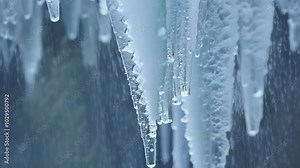 Close up of melting icicles with water droplets, bringing the promise of warmer weather. The melting ice creates a beautiful and abstract pattern