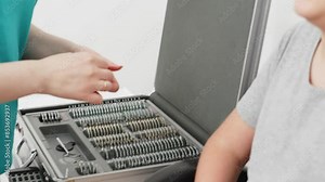 Happy little patient in an ophthalmology clinic. Eye test, cheerful child trying on trial frames during optometric examination for accuracy.