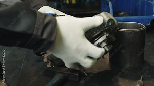 Close up of mechanic dismantling a car starter inspecting the insides of the starter