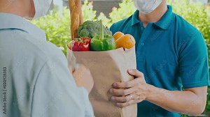 Food Delivery concept. Asian delivery man hand giving bag of food, fruit, vegetable delivery to costomer grocery delivery service.