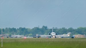 Business Jets Taking Off from Airport Viewed from Front with Runway Lights and Green Grass at Dusk
