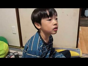 Takkun watches a YouTube video about gaming while holding a Kamen Rider Zeztz coloring book.