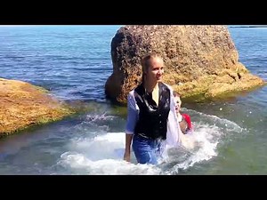 models get wet in the sea with their clothes on and play with each other