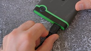 Portable hard drive connected to laptop to transfer data or documents, close-up