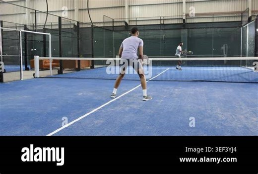 Diverse men starting rally backhanding padel ball over net and hitting forehand on padel court. Sport, competition, agility, indoors, athleticism, teamwork, training Stock Video Footage - Alamy