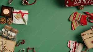 Colorful Christmas background 360 degree rotation shot on RED camera. Fir cones, red Santa mailbox, Christmas cookie cut out shapes, gift boxes in craft paper, candles spinning on green background 4K