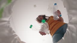 Woman Throwing Plastic Waste into a Trash