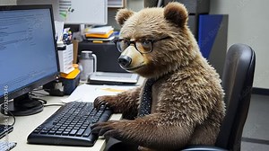 A bear in glasses sits at a desk, typing on a keyboard while dressed in a tie, blending the wild with an office setting Stock Video